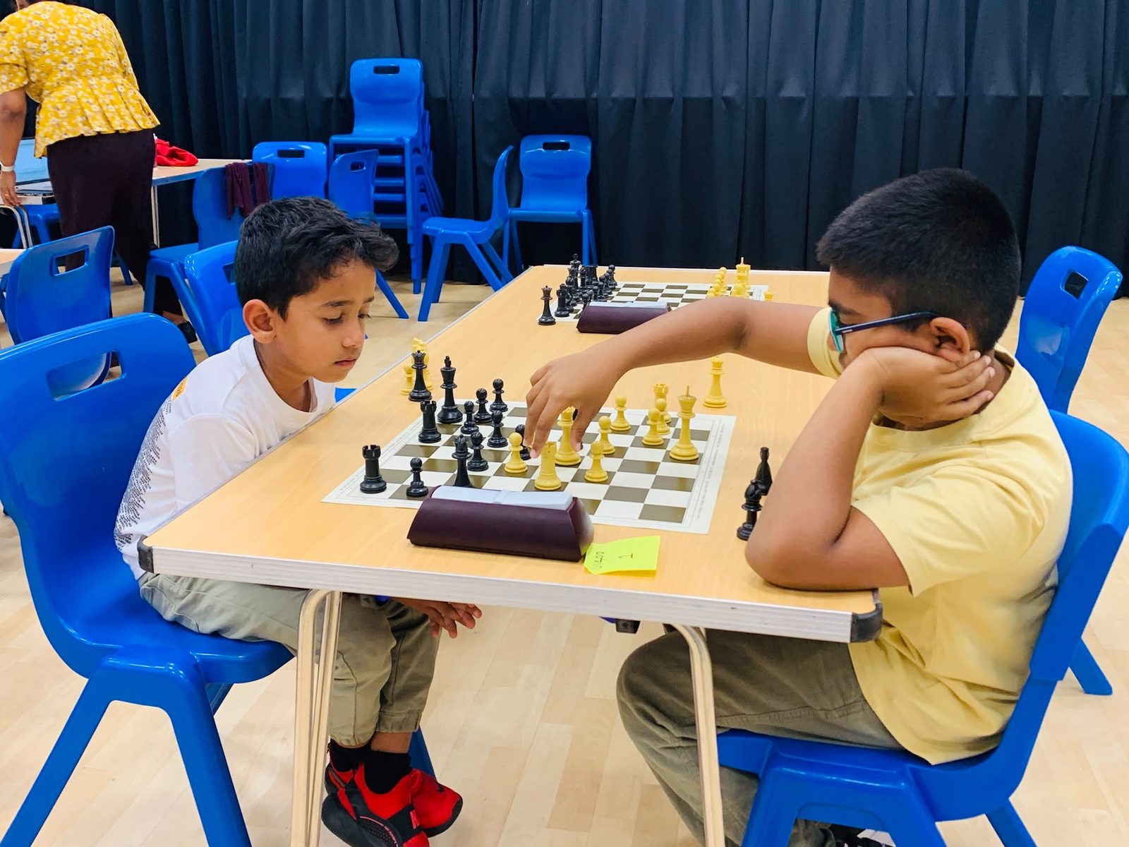 Chess players seated at boards during an A3C club session