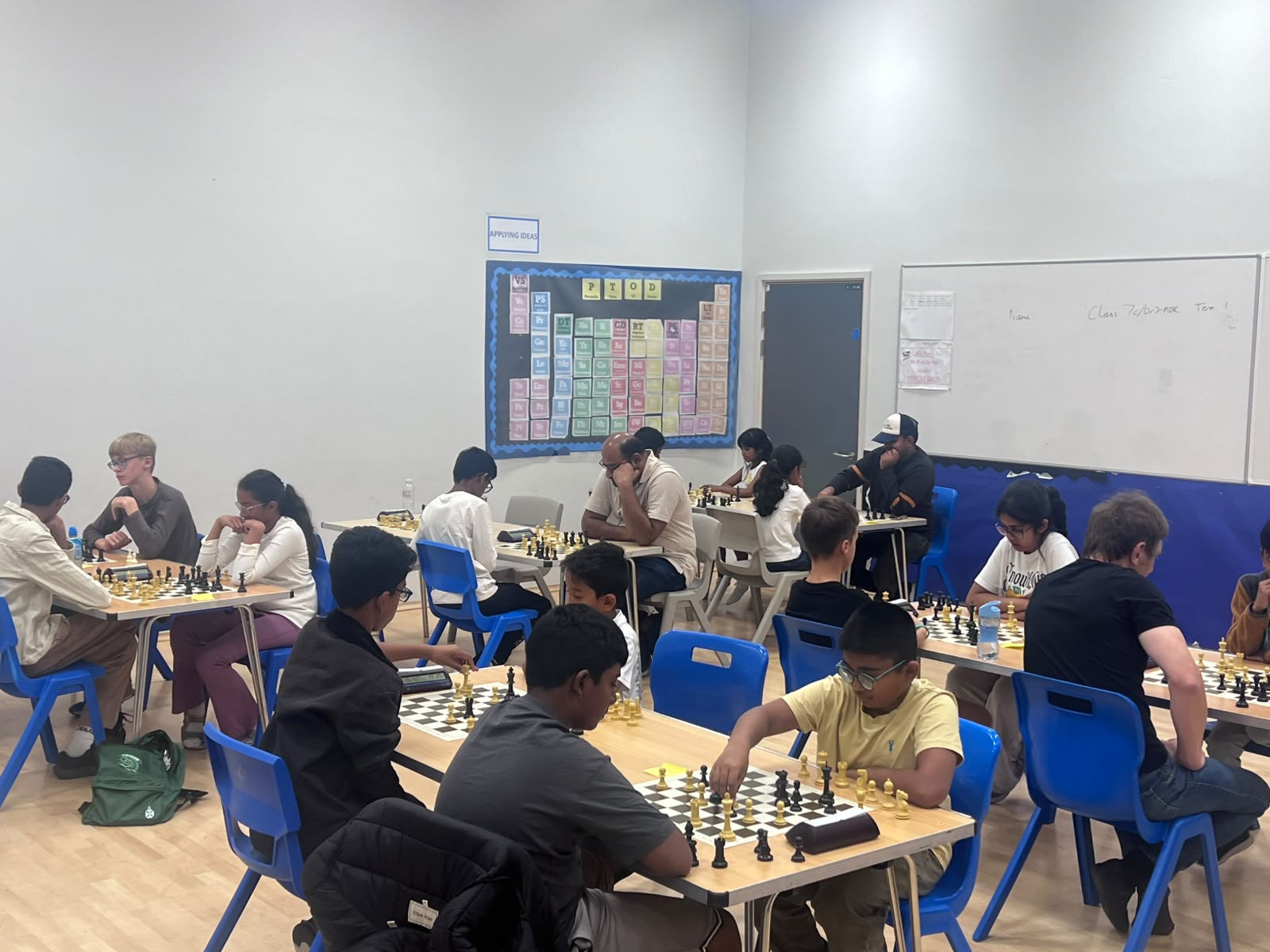 Chess players seated at boards during an A3C club session